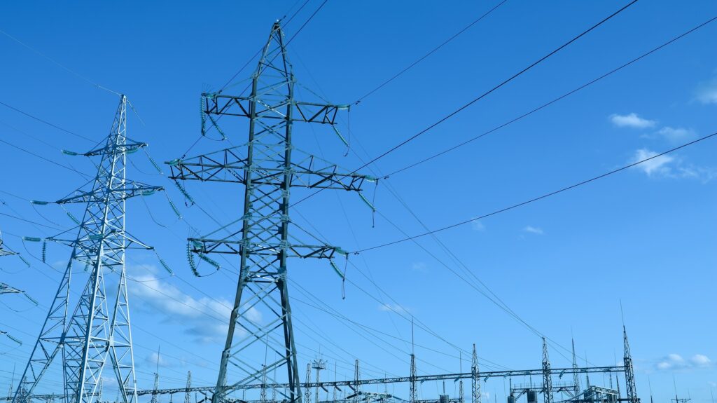 Impression network at transformer station in sunset, high voltage up to blue sky take with blue tone