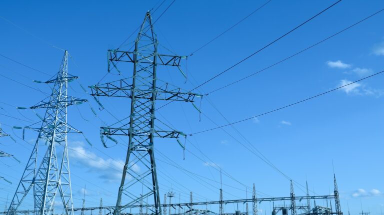 Impression network at transformer station in sunset, high voltage up to blue sky take with blue tone